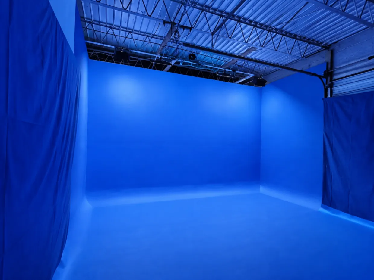 Blue cyclorama studio with a wide open floor and overhead rigging